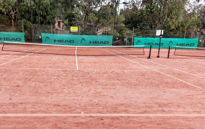 Empty clay tennis court in Melbourne Australia looking down the middle