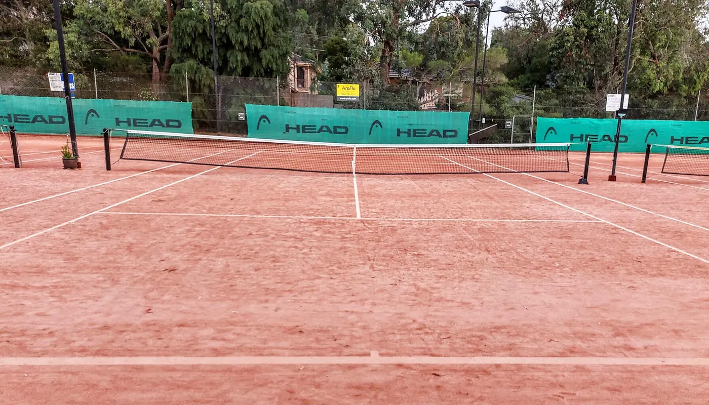 Empty clay tennis court in Melbourne Australia looking down the middle